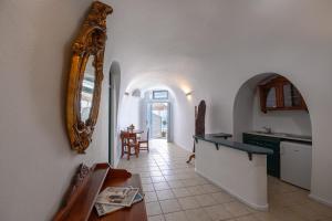 a kitchen with a mirror on the wall and a table at Nevma Suites in Firostefani