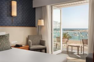 um quarto de hotel com uma cama e uma varanda com vista em Hotel Baia em Cascais