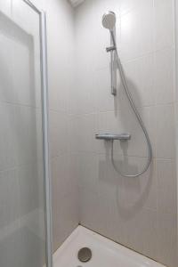 um chuveiro com uma porta de vidro na casa de banho em La maisonnette du Vivier em Couffy