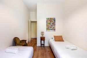 a room with two beds and a painting on the wall at GuestReady - Prime haven in Montparnasse in Paris
