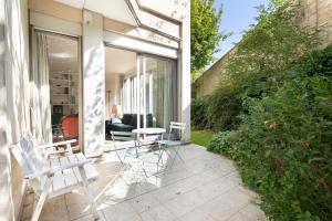 a patio with chairs and a table and a couch at GuestReady - Prime haven in Montparnasse in Paris