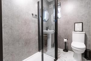 a bathroom with a shower with a toilet and a sink at Railway Retreat in Wakefield