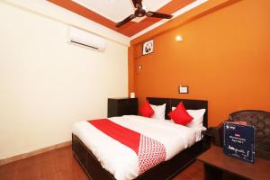 a bedroom with a bed with red pillows at Flagship Hotel Sweet Night in Ghaziabad