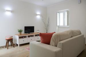 a living room with a couch and a flat screen tv at A Janela do Conforto in Reguengos de Monsaraz