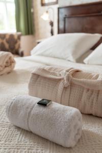 a bed with a white towel with a remote control on it at Boutique Hotel Anna by EJ Hotels in Holt