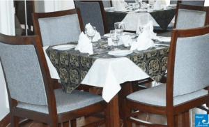 a table with chairs and a table cloth on it at Hotel Javson in Sialkot