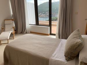 a bedroom with a bed and a large window at BYPILLOW Cap Sa Sal in Begur