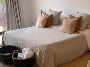 a large bed with pillows and a basket on it at BYPILLOW Cap Sa Sal in Begur