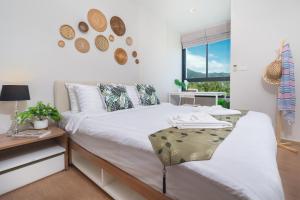 a bedroom with a bed and a desk and a window at ZcapeX2 Condo near Boat Avenue & Laguna in Bang Tao Beach