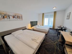 Habitación de hotel con 2 camas y mesa en Hotel Valcha en Praga