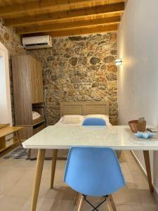 a table and two blue chairs in a room at SPITAKI in Kalymnos