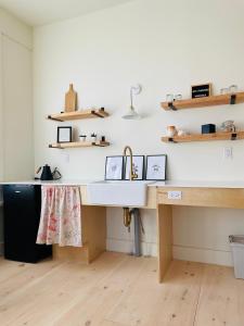 a kitchen with a sink and wooden shelves at The August House in Windsor