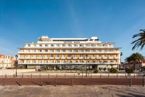 a large building in front of a beach at Hotel Baia in Cascais
