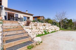 a stone retaining wall next to a house at La Tendresse - Maison Familliale avec Piscine in Mondonville