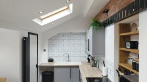 a kitchen with a sink and a brick wall at Mrs Seeleys House in Choppington
