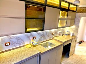 a kitchen with a sink and a counter top at شقة جديدة بالكامل in Port Said