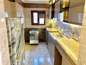 a kitchen with a sink and a stove at شقة جديدة بالكامل in Port Said