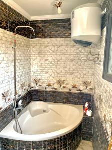 a bath tub in a bathroom with tiled walls at شقة جديدة بالكامل in Port Said