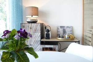 una sala de estar con una mesa con una lámpara y flores en Les Hauts d'Avignon, en Rochefort-du-Gard