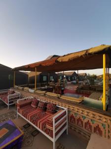 The Friendly Camp في زاكورة: مجموعة طاولات وكراسي تحت خيمة