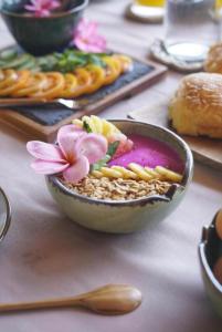 Sunny Rose Bungalows Gili Air في غيلي آير: وعاء من الطعام مع وردة وردية على طاولة