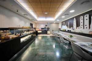 un restaurante con mesas y sillas y una panadería en Catalonia Rigoletto, en Barcelona