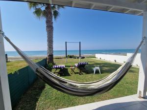 a hammock on the side of a beach at Ammos Beachfront Villa Paradise in Larnaka
