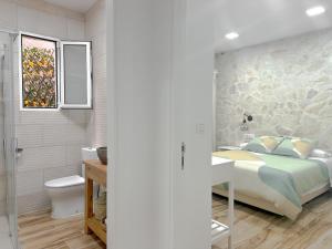 a bedroom with a bed and a bathroom with a toilet at El Hortal i lloo in El Cuervo