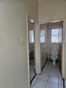 an empty bathroom with a toilet and a window at Stay Sunrise in Nelspruit
