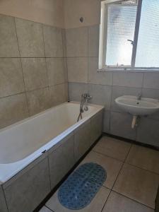 een badkamer met een bad en een wastafel bij Stay Sunrise in Nelspruit