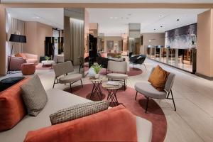 a lobby with couches and chairs in a store at NH Bologna De La Gare in Bologna