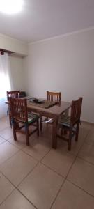 a wooden table with two wooden chairs and a table and a table at Hola Tres Arroyos in Tres Arroyos