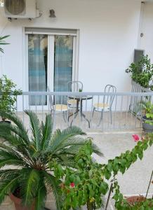 een balkon met een tafel, stoelen en planten bij Dream apartment in Kallithea in Athene