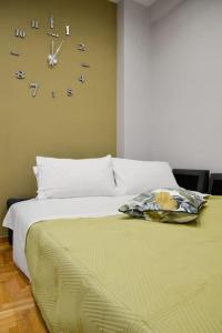 a bedroom with two beds and a clock on the wall at Dream apartment in Kallithea in Athens