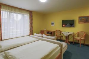 um quarto de hotel com duas camas e uma mesa em Hotel Ideal em Lübeck