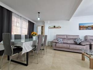 sala de estar con mesa de comedor y sofá en DICHA 24, en Sevilla