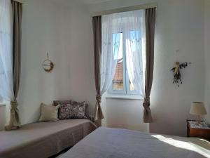 a bedroom with two beds and a window at APARTMAN RIVA 2 in Komiža