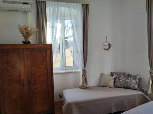 a bedroom with a bed and a window at APARTMAN RIVA 2 in Komiža