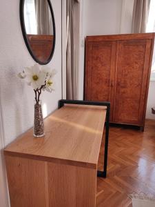 un vaso con fiori su un tavolo di legno in una stanza di APARTMAN RIVA 2 a Komiža