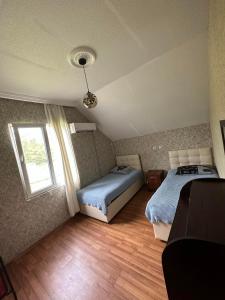 a bedroom with two beds and a window at Natali & Giga in Ureki
