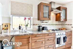 a kitchen with wooden cabinets and a sink at Double Room with a shared Kitchen and bathroom in a 5-Bedroom House at Hanwell in Hanwell