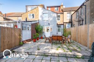 a backyard with a wooden fence and a table at Double Room with a shared Kitchen and bathroom in a 5-Bedroom House at Hanwell in Hanwell