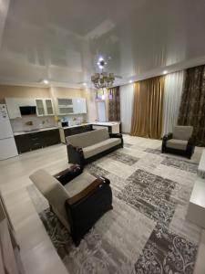sala de estar con sofá y sillas y cocina en 2х комнатная квартира, en Shymkent
