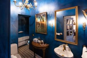 uma casa de banho azul com um lavatório e um espelho em Vinoteegi Residents em Kuressaare