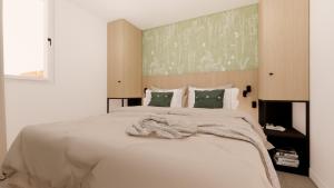 ein Schlafzimmer mit einem großen weißen Bett mit einer Decke in der Unterkunft Vakantiewoning Westkapelle Piet Mondriaanpad 1 in Westkapelle