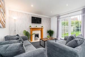 sala de estar con 2 sofás y chimenea en Delightful House with Garden, en Sherburn in Elmet