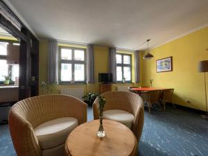 una habitación con sillas y una mesa con un jarrón en Warener Hof Apartments, en Waren