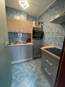 a kitchen with stainless steel appliances and gray tiles at Warener Hof Apartments in Waren