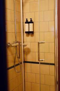 baño con ducha y 2 botellas en la pared en Hotel Omega, en Ámsterdam