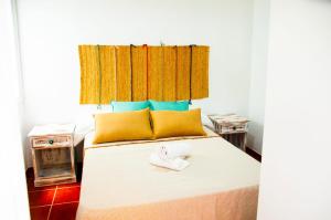 a bedroom with a bed with yellow and blue pillows at Famara Surf in Famara